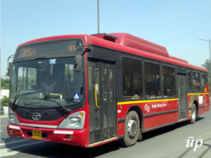 A red AC bus being utilized by Delhi Transport Corporation.